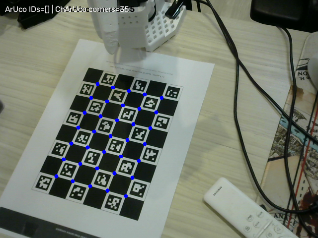 Workspace camera view of the SO-ARM101 gripper above a ChArUco board